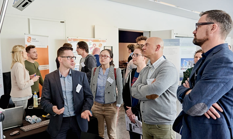 people standing at a booth at smart production day, an event in Antwerp.